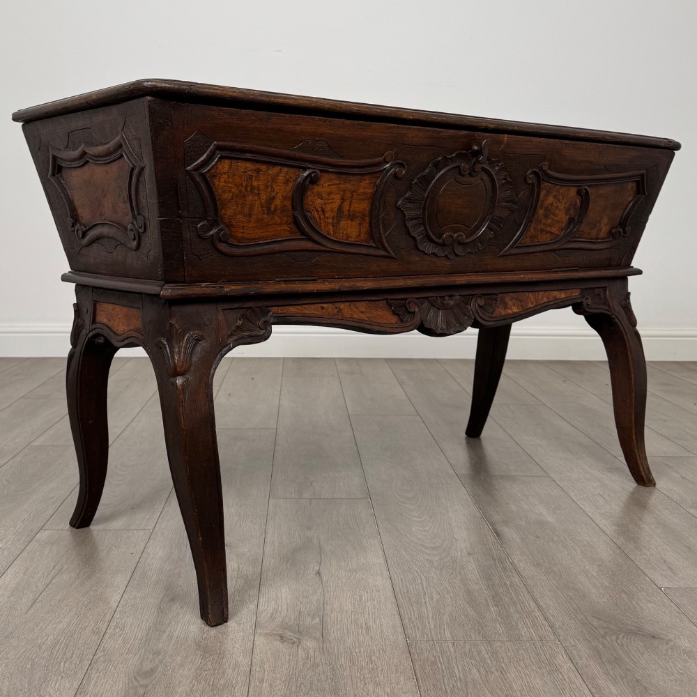 A nineteenth-century French provincial walnut dough bin featuring hand-carved central cartouche ornamentation and shaped cabriole legs. View VIII