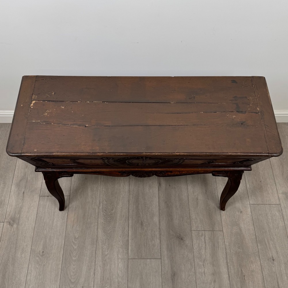 A nineteenth-century French provincial walnut dough bin featuring hand-carved central cartouche ornamentation and shaped cabriole legs. View IX