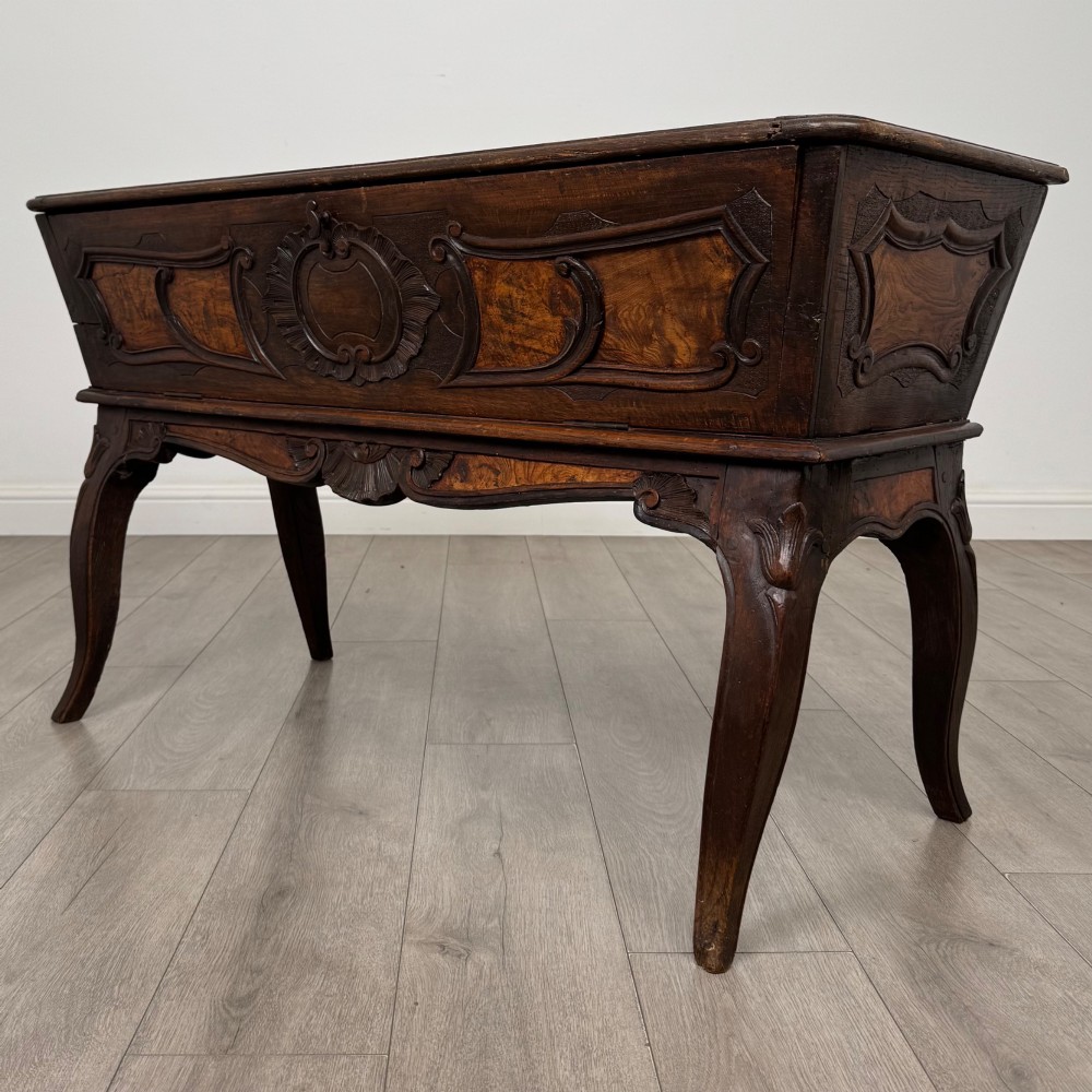 A nineteenth-century French provincial walnut dough bin featuring hand-carved central cartouche ornamentation and shaped cabriole legs. View X