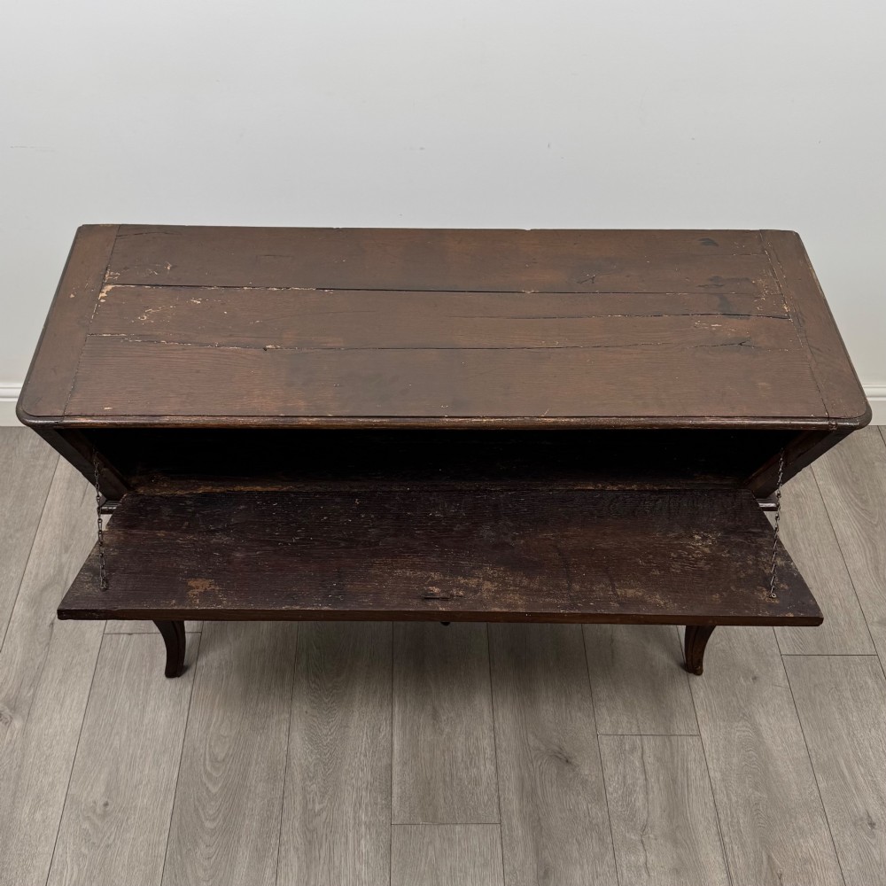 A nineteenth-century French provincial walnut dough bin featuring hand-carved central cartouche ornamentation and shaped cabriole legs. View XI