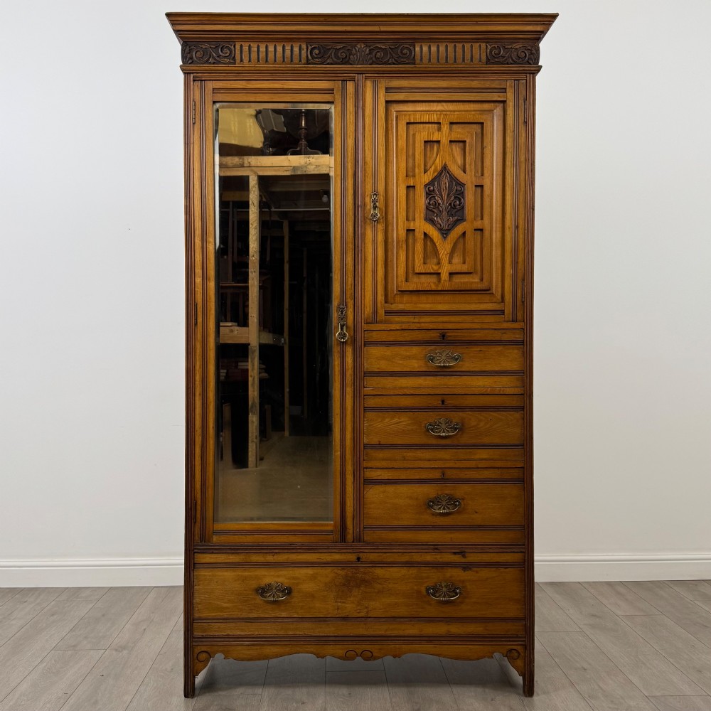A 19th-century ash compactum wardrobe featuring a full-length mirrored door on the left and a carved cupboard with four drawers on the right above a long base drawer.
