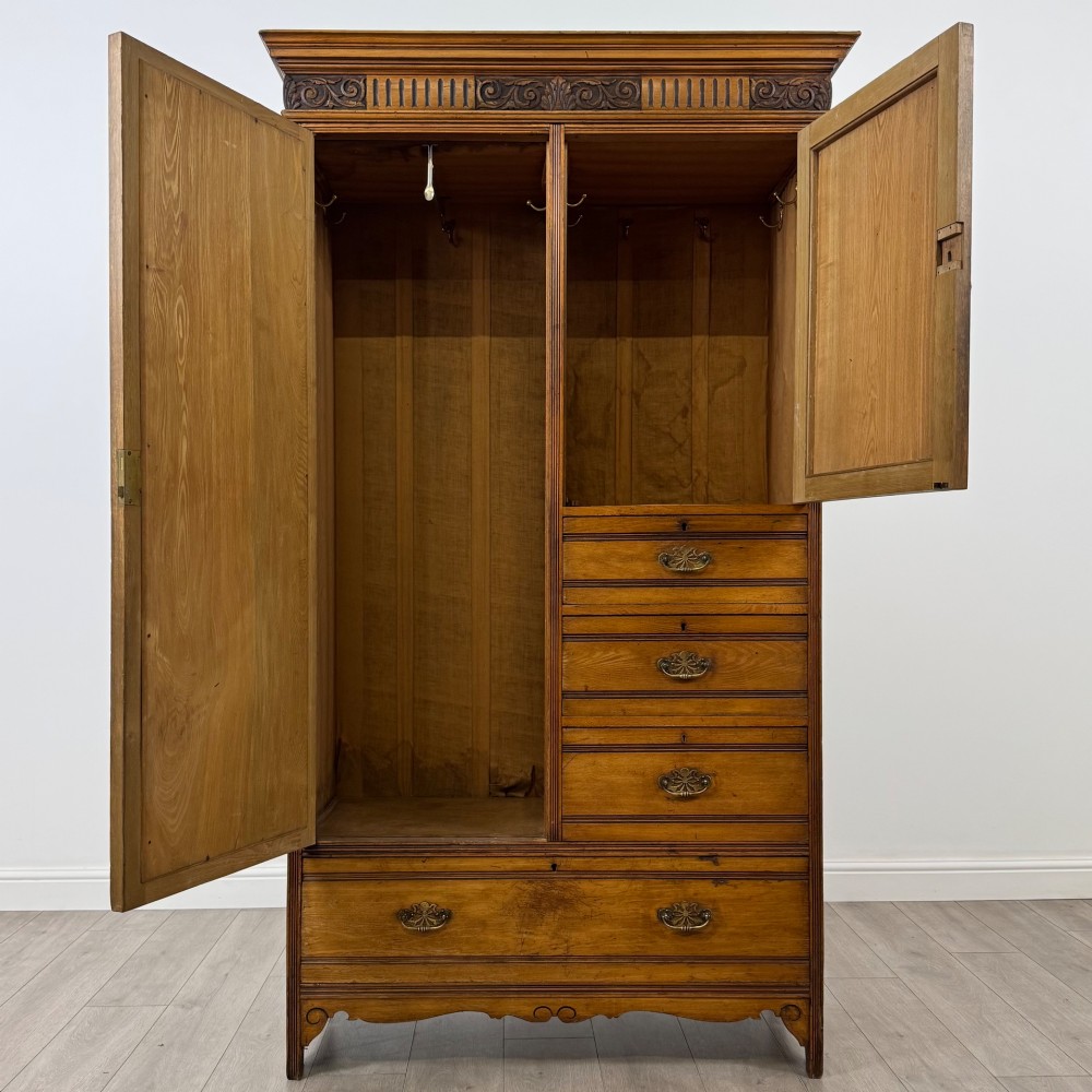 A 19th-century ash compactum wardrobe featuring a full-length mirrored door on the left and a carved cupboard with four drawers on the right above a long base drawer. View II
