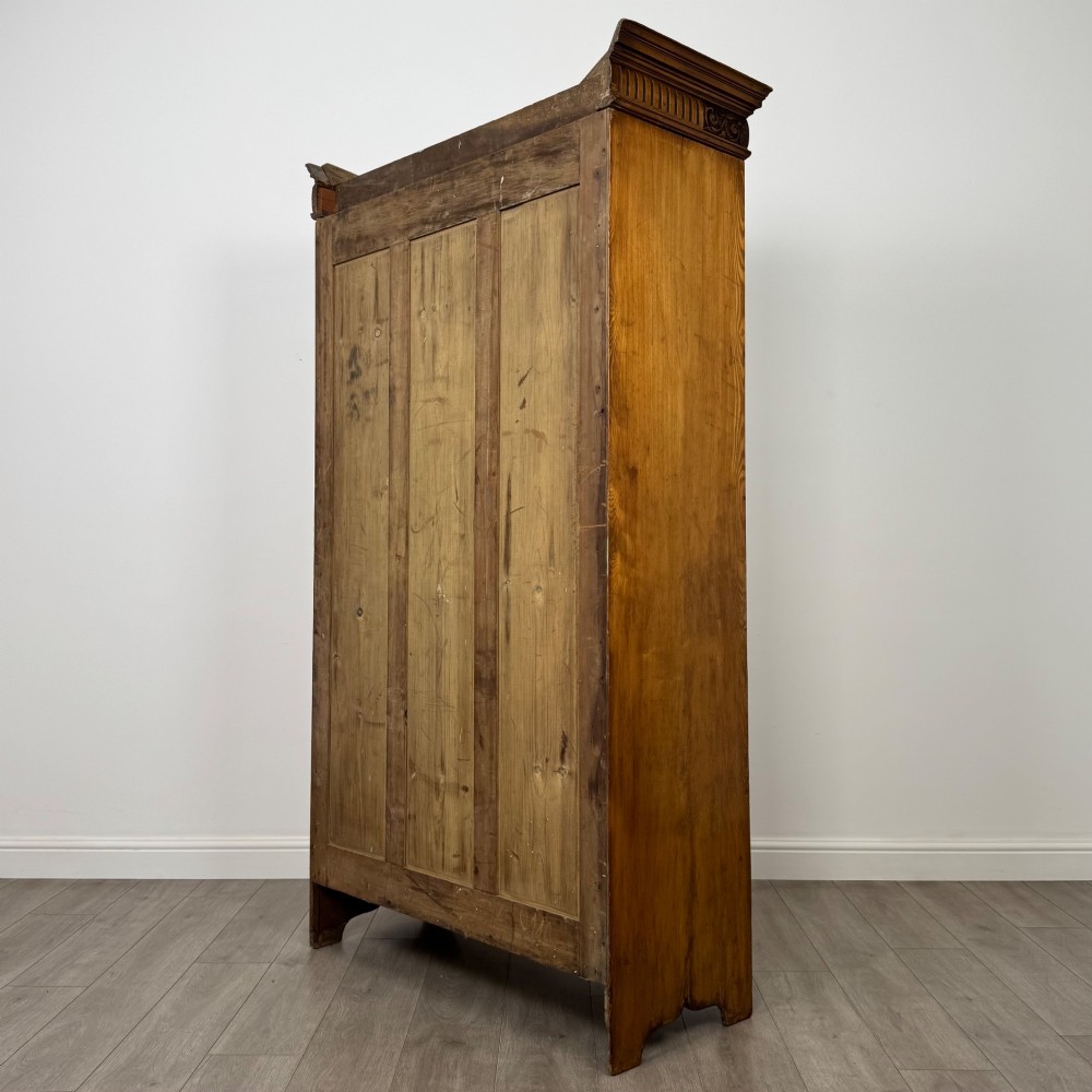 A 19th-century ash compactum wardrobe featuring a full-length mirrored door on the left and a carved cupboard with four drawers on the right above a long base drawer. View VII