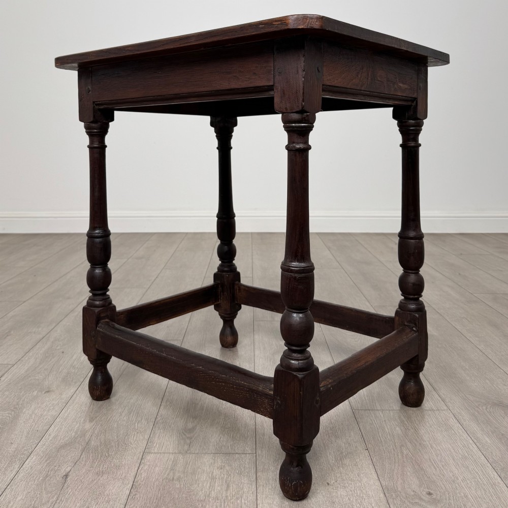 An antique dark oak side table featuring a rectangular flat top, four turned legs, and a lower four-sided stretcher base. View II