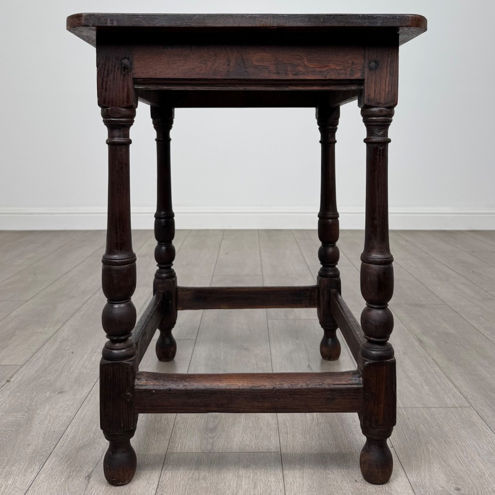 An antique dark oak side table featuring a rectangular flat top, four turned legs, and a lower four-sided stretcher base. View III