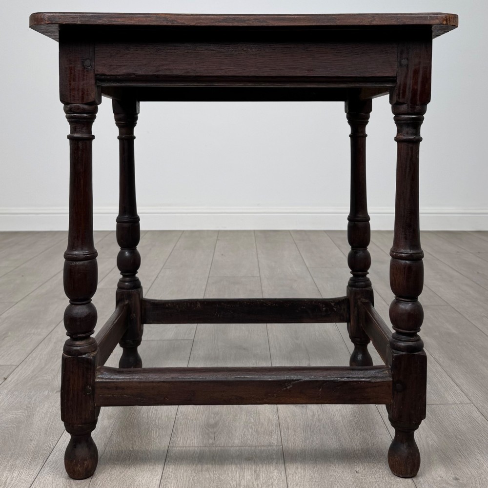 An antique dark oak side table featuring a rectangular flat top, four turned legs, and a lower four-sided stretcher base. View V