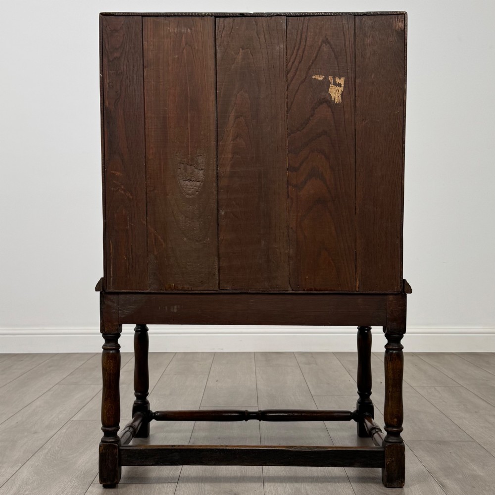 A dark oak antique bureau featuring a slanted drop-front lid above two drawers, supported by turned legs and stretchers. View VI