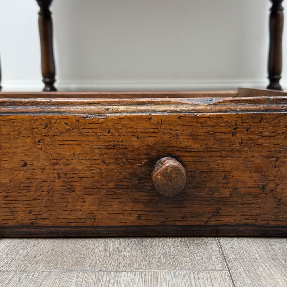 A dark oak antique bureau featuring a slanted drop-front lid above two drawers, supported by turned legs and stretchers. View XIII