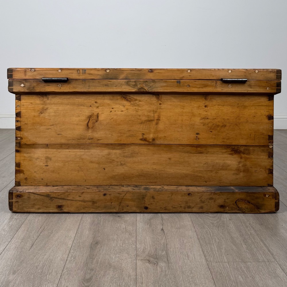 A nineteenth-century pine storage chest featuring visible hand-cut dovetail corner joints and a moulded base. View V