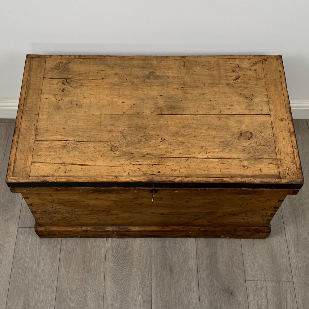 A nineteenth-century pine storage chest featuring visible hand-cut dovetail corner joints and a moulded base. View IX