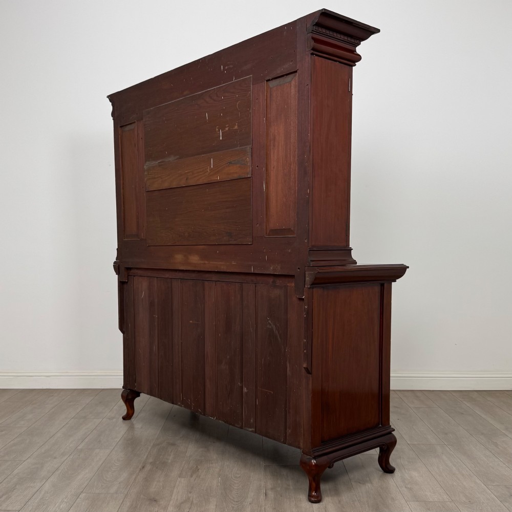 An Arts and Crafts dark mahogany sideboard featuring an upper mirrored superstructure flanked by leaded glass cabinet doors above lower drawers and carved cupboards. View VII