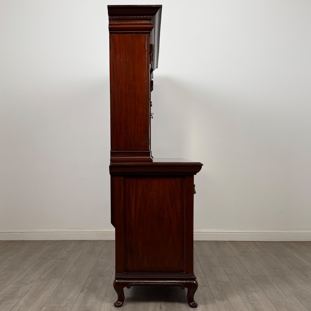 An Arts and Crafts dark mahogany sideboard featuring an upper mirrored superstructure flanked by leaded glass cabinet doors above lower drawers and carved cupboards. View VIII