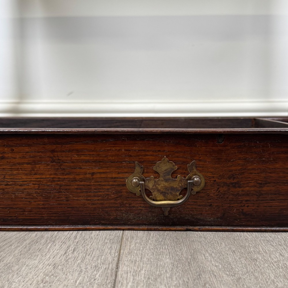 A dark oak side table featuring a single wide drawer with brass drop handles, a scalloped apron, turned legs, and lower stretchers. View XI