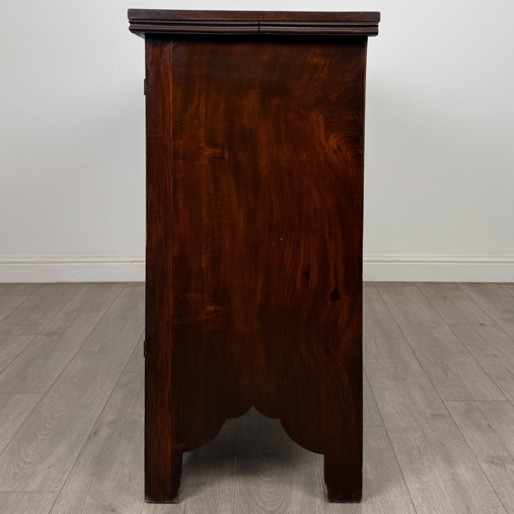 A dark oak Gothic Revival sideboard featuring three central drawers with metal drop ring handles, flanked by two carved tracery panel doors with decorative iron latches. View IV