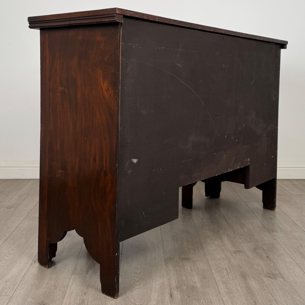 A dark oak Gothic Revival sideboard featuring three central drawers with metal drop ring handles, flanked by two carved tracery panel doors with decorative iron latches. View V