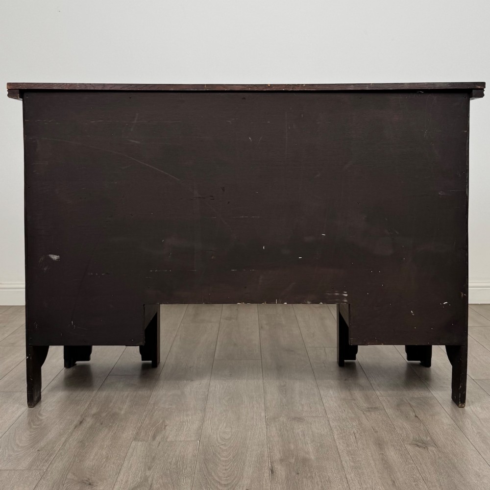 A dark oak Gothic Revival sideboard featuring three central drawers with metal drop ring handles, flanked by two carved tracery panel doors with decorative iron latches. View VI