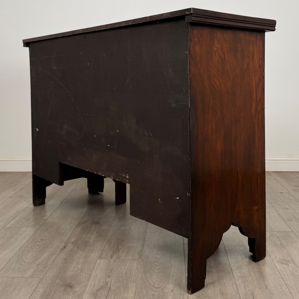 A dark oak Gothic Revival sideboard featuring three central drawers with metal drop ring handles, flanked by two carved tracery panel doors with decorative iron latches. View VII