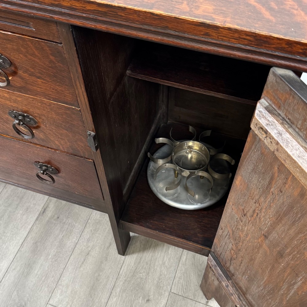 A dark oak Gothic Revival sideboard featuring three central drawers with metal drop ring handles, flanked by two carved tracery panel doors with decorative iron latches. View XIV