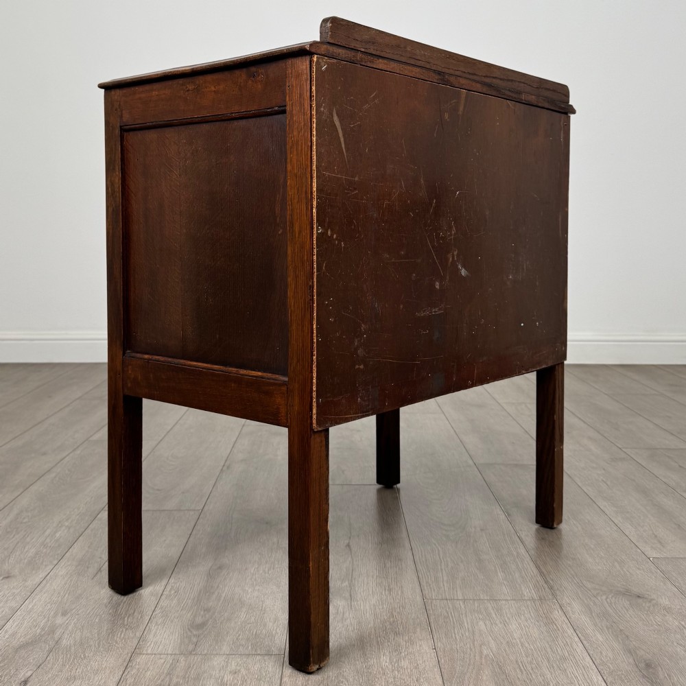 A two-drawer golden oak chest of drawers featuring decorative metal drop handles and straight square legs. View IV