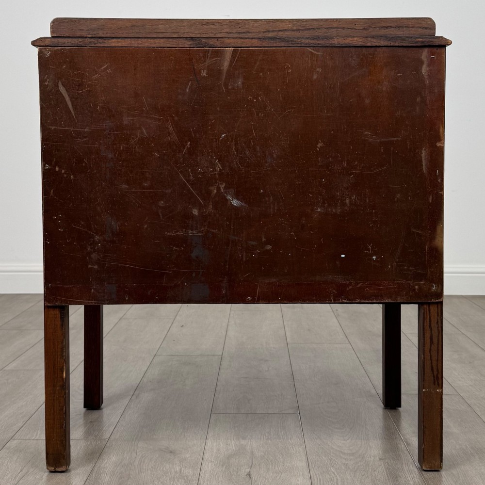 A two-drawer golden oak chest of drawers featuring decorative metal drop handles and straight square legs. View V