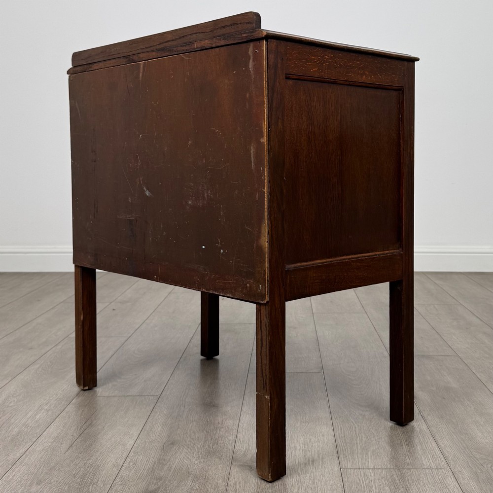 A two-drawer golden oak chest of drawers featuring decorative metal drop handles and straight square legs. View VI