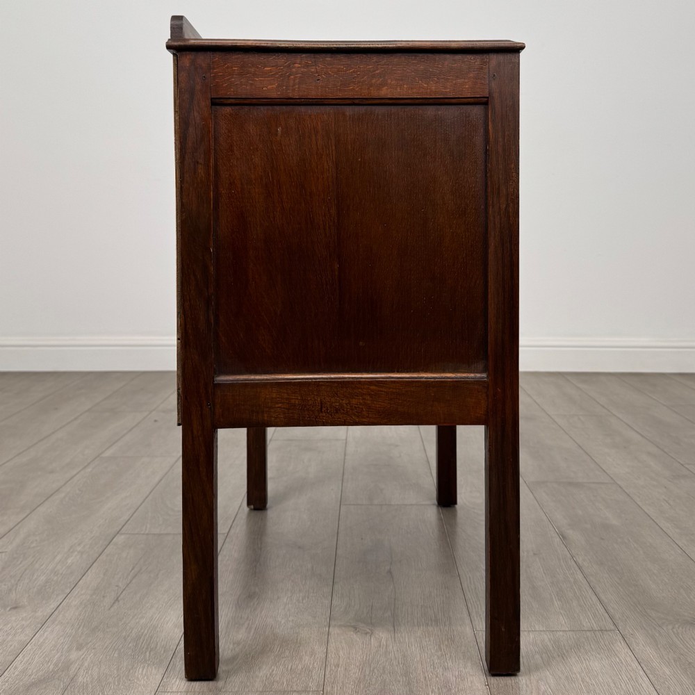 A two-drawer golden oak chest of drawers featuring decorative metal drop handles and straight square legs. View VII
