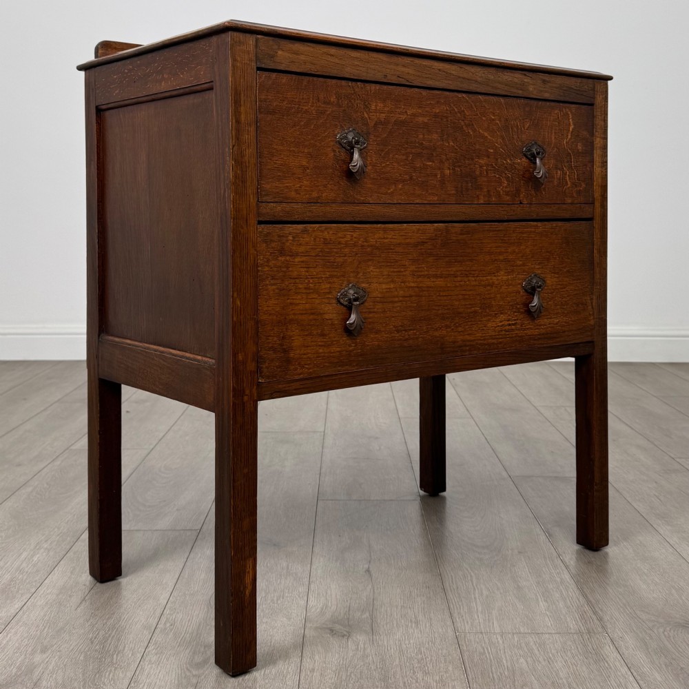 A two-drawer golden oak chest of drawers featuring decorative metal drop handles and straight square legs. View VIII