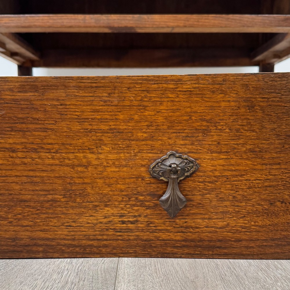 A two-drawer golden oak chest of drawers featuring decorative metal drop handles and straight square legs. View XI