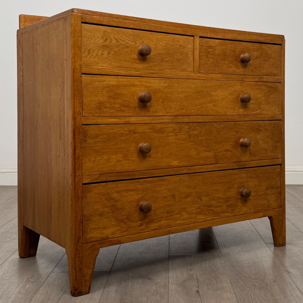 An antique golden oak chest of drawers featuring two short drawers above three long drawers with turned wooden knobs. View VIII