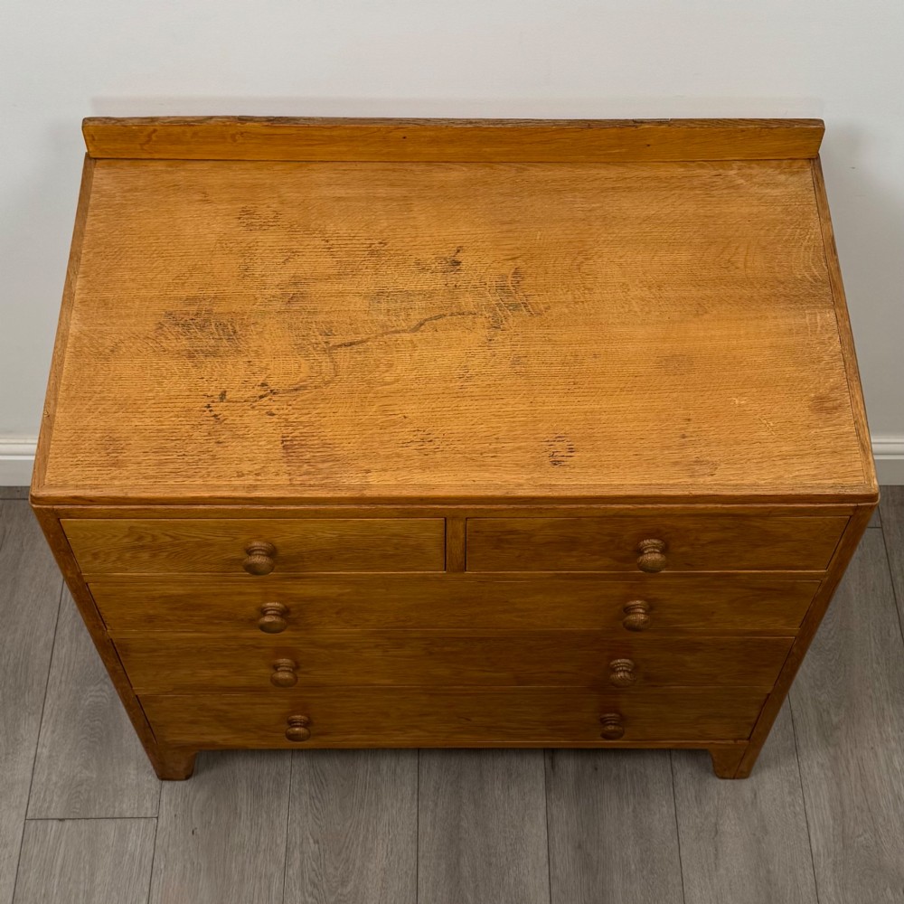 An antique golden oak chest of drawers featuring two short drawers above three long drawers with turned wooden knobs. View IX
