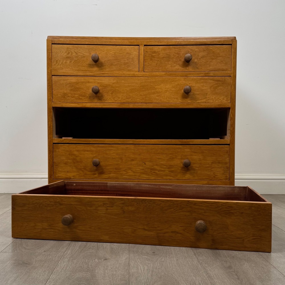 An antique golden oak chest of drawers featuring two short drawers above three long drawers with turned wooden knobs. View X
