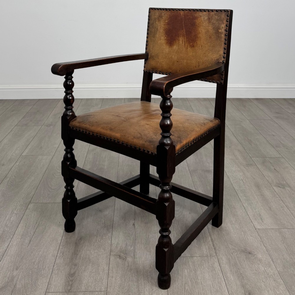 A set of six Edwardian dark oak dining chairs with tan studded leather upholstery, comprising two carver armchairs and four side chairs featuring turned legs. View II