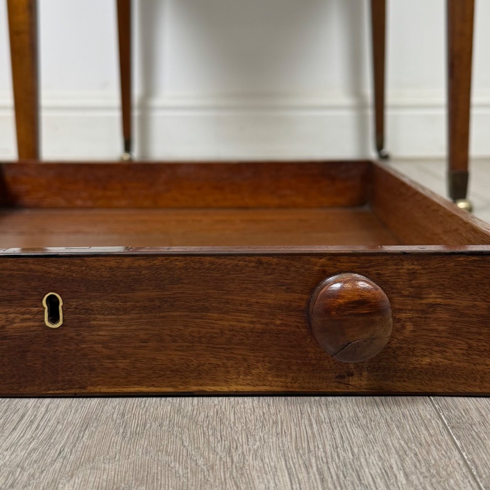 A 19th-century Georgian mahogany Pembroke table featuring two hinged drop-leaf sides, a single drawer with wooden knobs, and square tapered legs on brass castors. View XIII