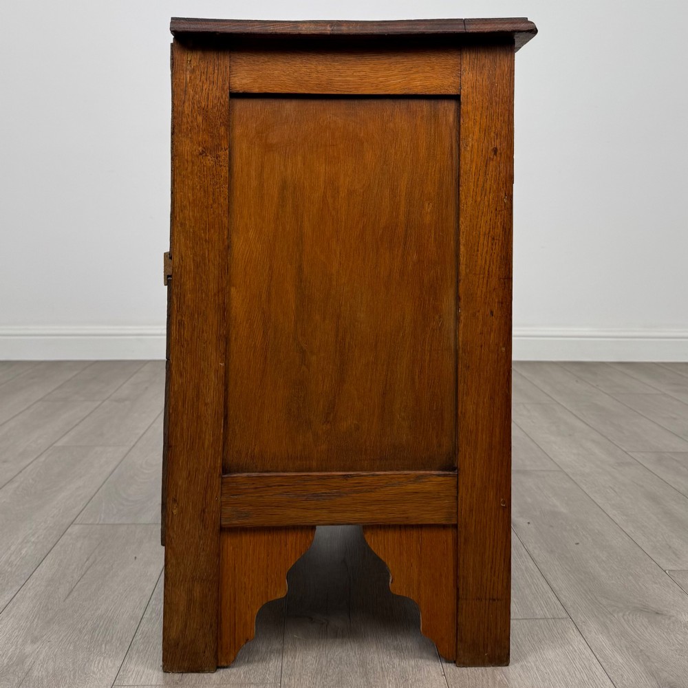 An Edwardian warm brown oak chest of drawers featuring two short upper drawers and two long lower drawers with brass drop handles. View VII
