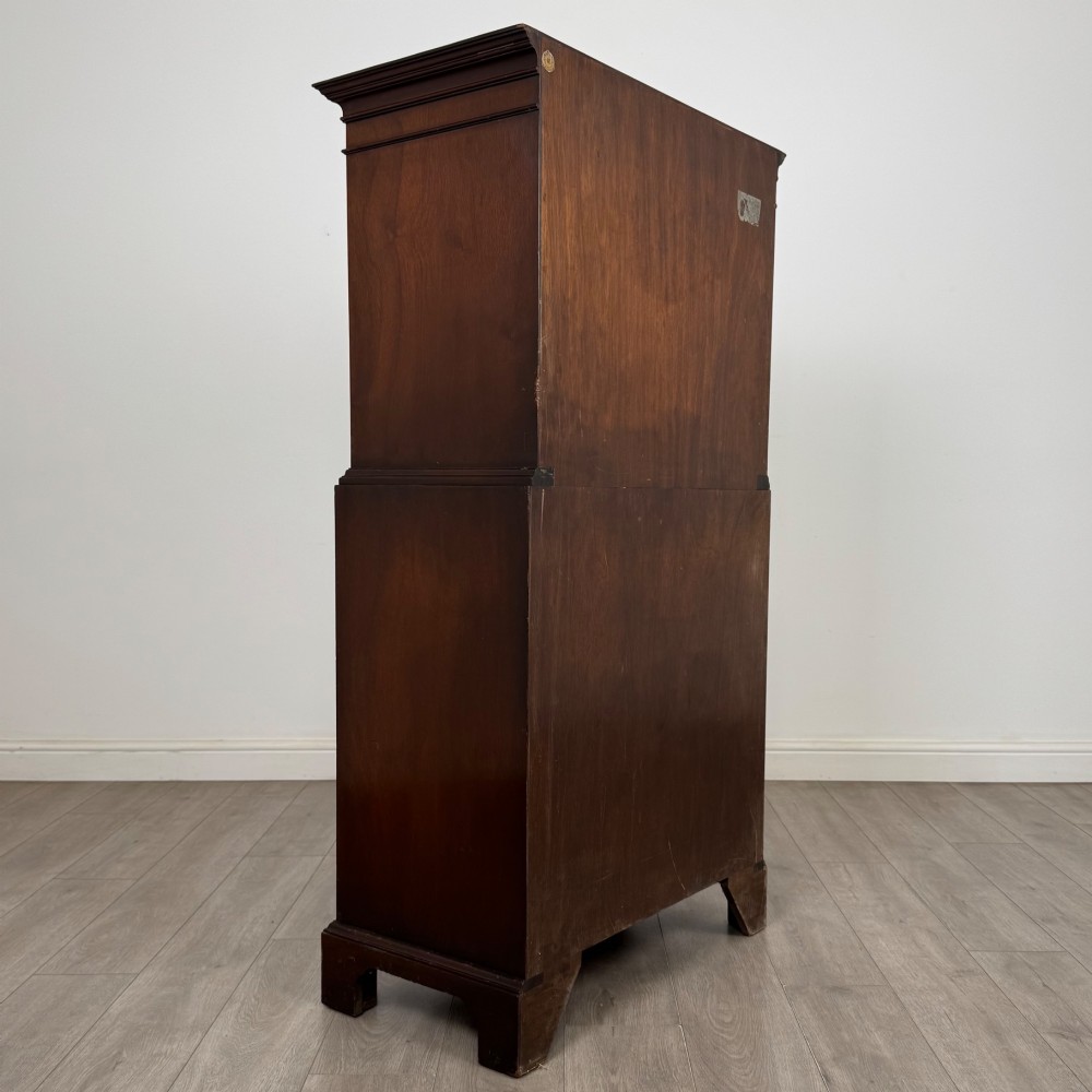 A tall 20th-century mahogany serpentine chest of drawers featuring seven graduated drawers with brass handles and bracket feet. View IV