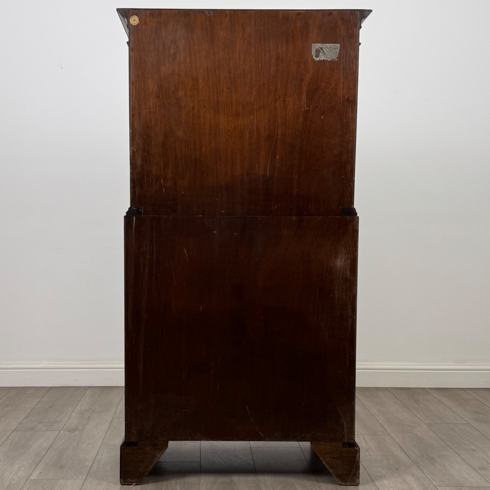 A tall 20th-century mahogany serpentine chest of drawers featuring seven graduated drawers with brass handles and bracket feet. View V