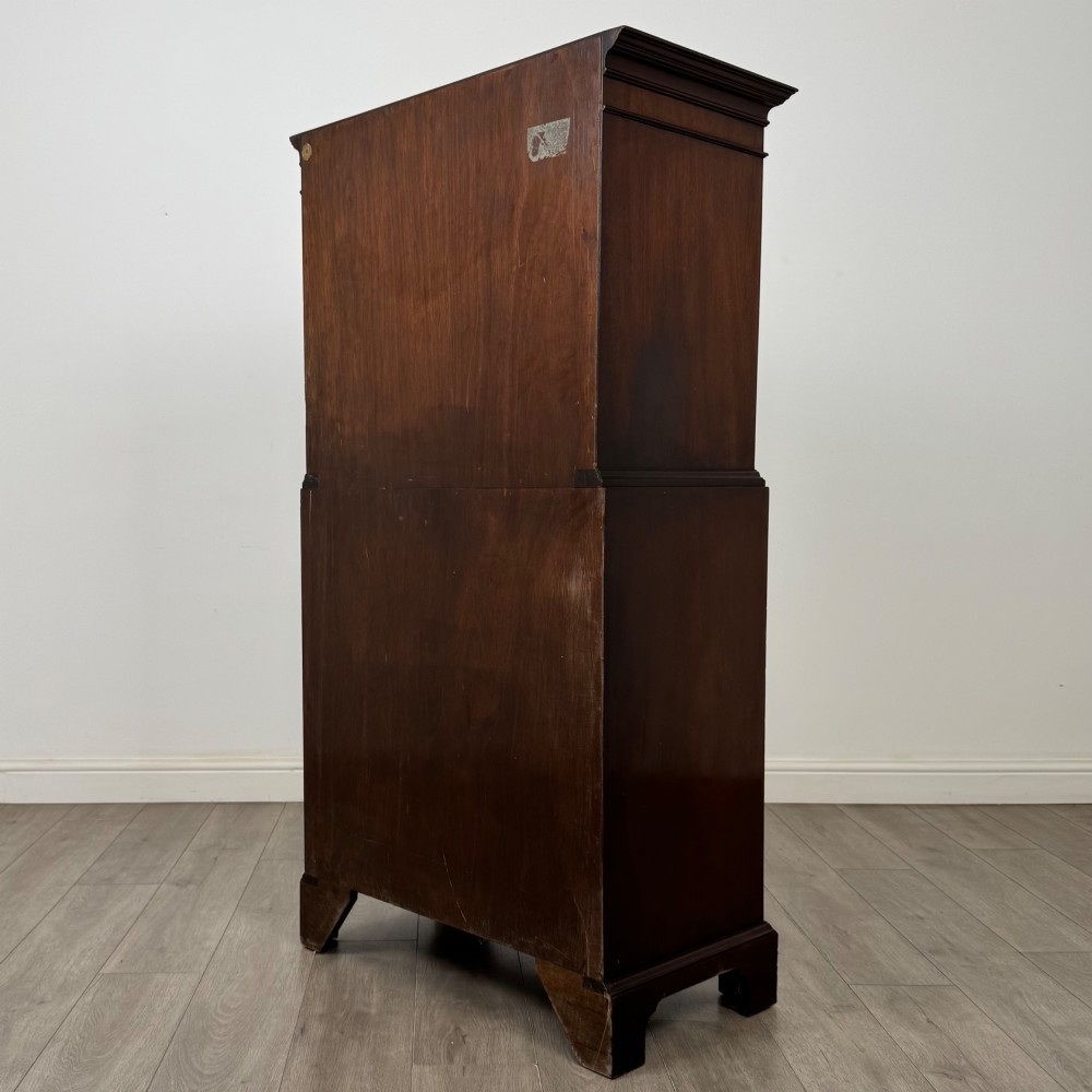 A tall 20th-century mahogany serpentine chest of drawers featuring seven graduated drawers with brass handles and bracket feet. View VI