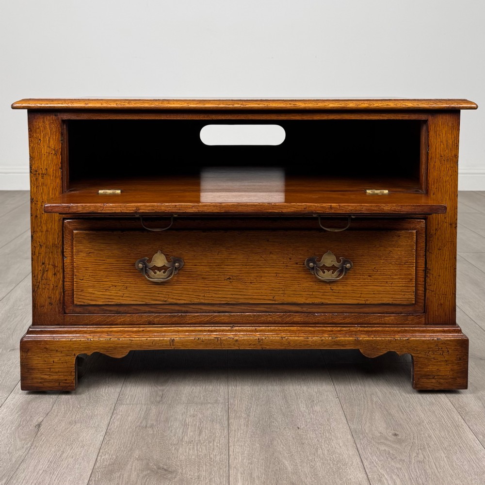 A low two-drawer oak chest featuring raised panel fronts, decorative brass drop handles, and bracket feet in a warm brown finish. View II