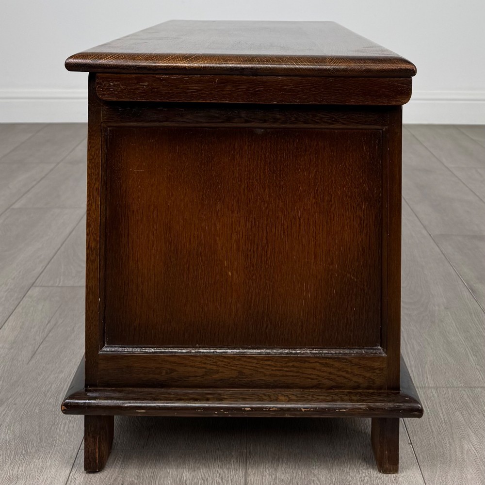 A rectangular dark oak blanket box featuring three carved front panels with Gothic arched details and a flat top lid. View III