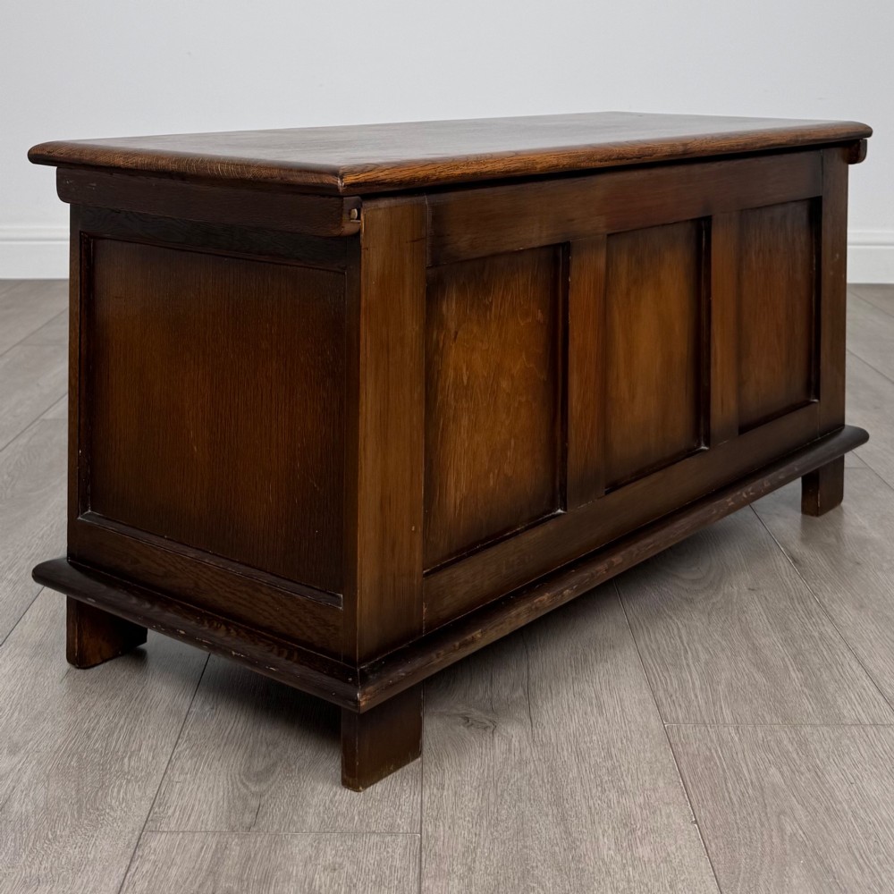 A rectangular dark oak blanket box featuring three carved front panels with Gothic arched details and a flat top lid. View IV