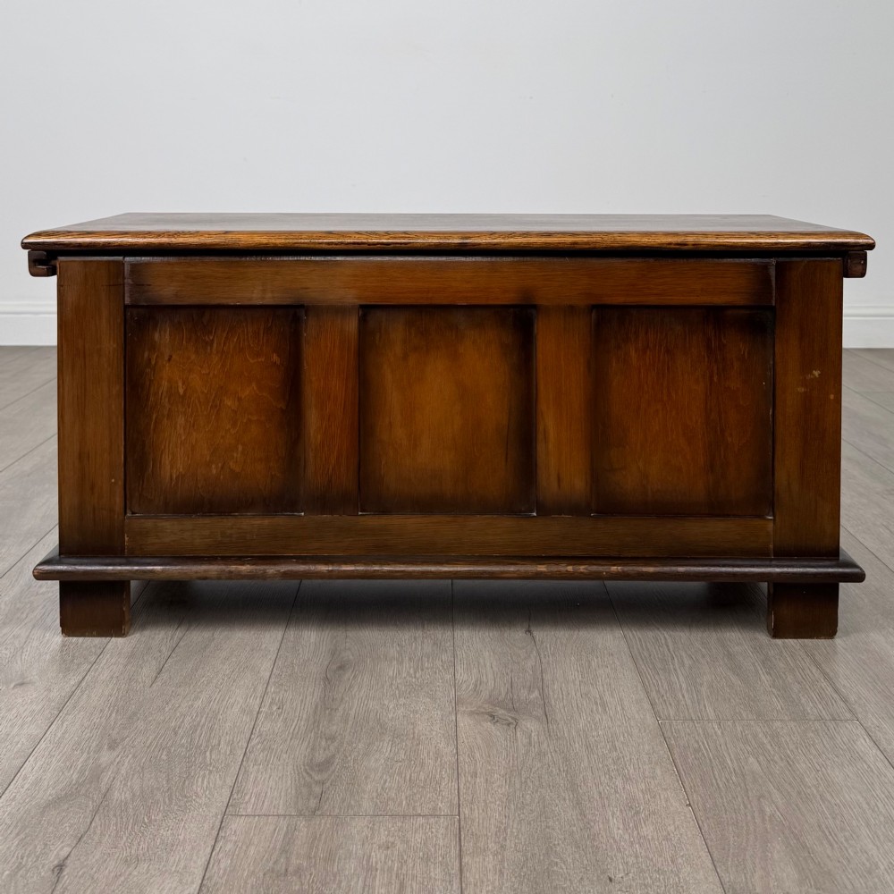 A rectangular dark oak blanket box featuring three carved front panels with Gothic arched details and a flat top lid. View V