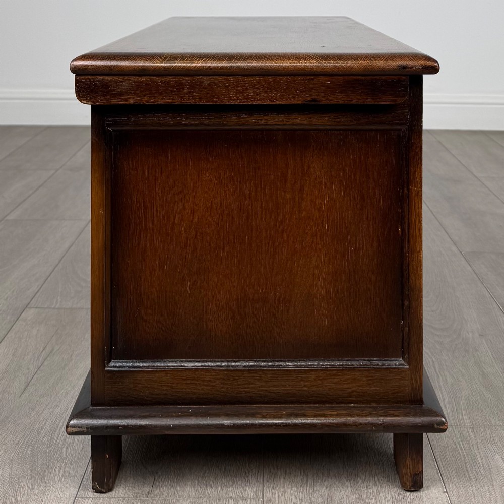 A rectangular dark oak blanket box featuring three carved front panels with Gothic arched details and a flat top lid. View VII