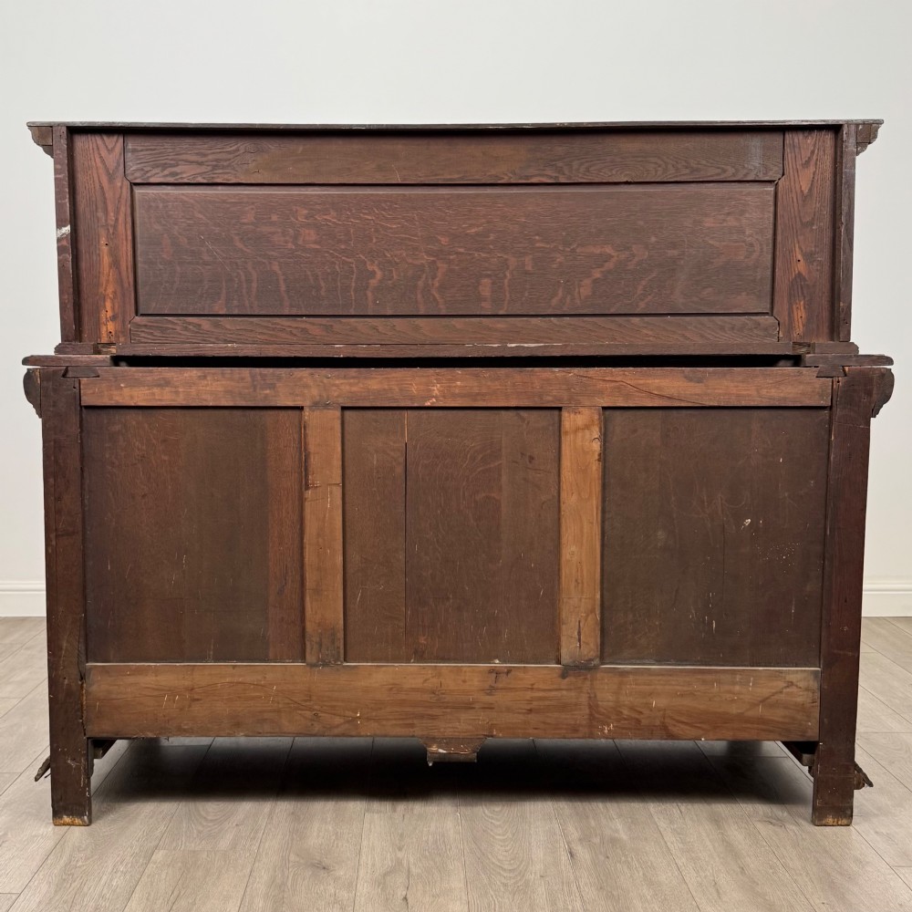 A dark oak 19th-century sideboard featuring deep relief carvings of Green Man mythical faces, foliate motifs, lion masks, and an arched upper gallery shelf. View VI