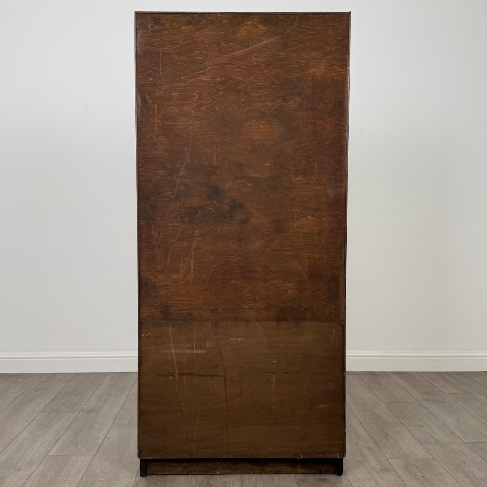 A tall vintage golden oak display cabinet featuring glazed sliding doors on top and a two-door cupboard base. View VII