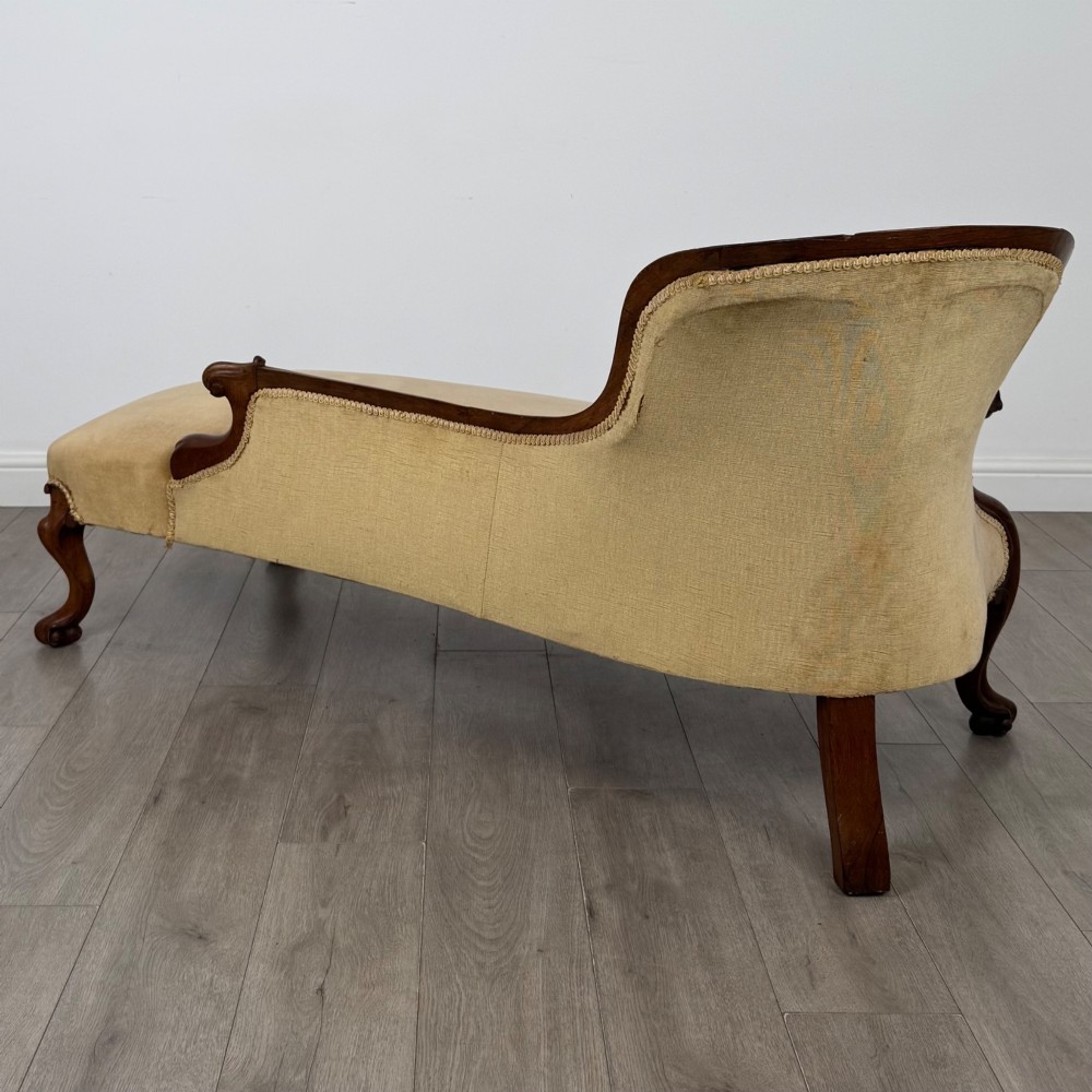 A Victorian mahogany chaise longue featuring ochre velvet button-backed upholstery, carved trim, and cabriole legs. View VI