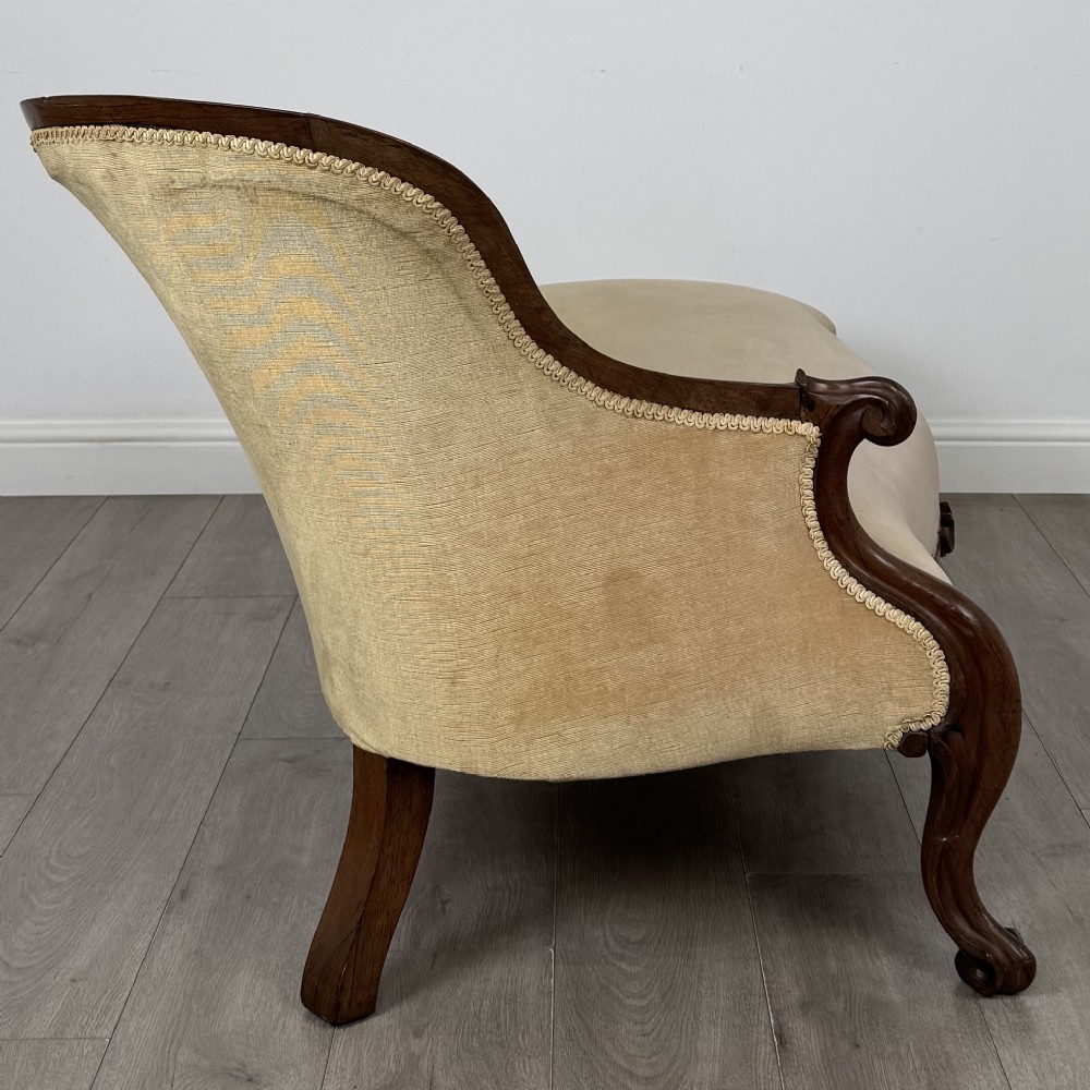 A Victorian mahogany chaise longue featuring ochre velvet button-backed upholstery, carved trim, and cabriole legs. View VII