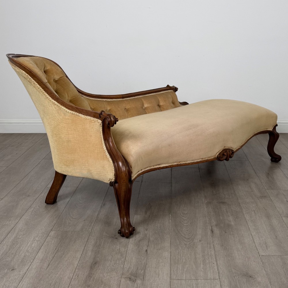 A Victorian mahogany chaise longue featuring ochre velvet button-backed upholstery, carved trim, and cabriole legs. View VIII