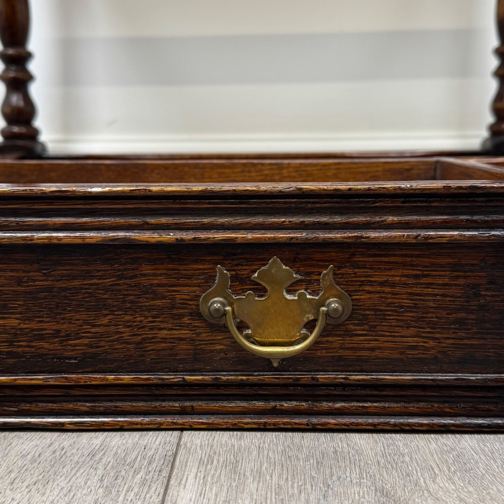 A dark oak side table featuring a single drawer with brass drop handles, turned legs, and a perimeter box stretcher. View XI