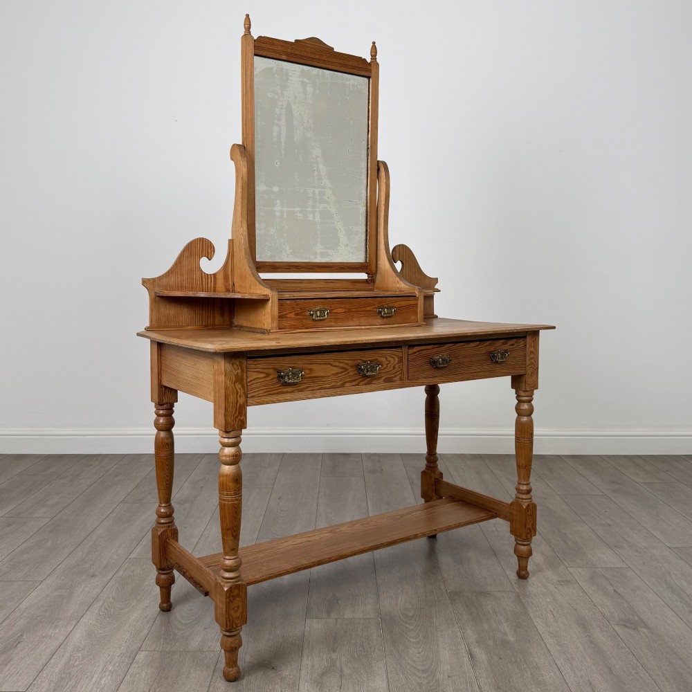 A Victorian pitch pine dressing table featuring a central swivel mirror, side scroll shelves, frieze drawers with brass handles, and turned legs with a low shelf. View VIII