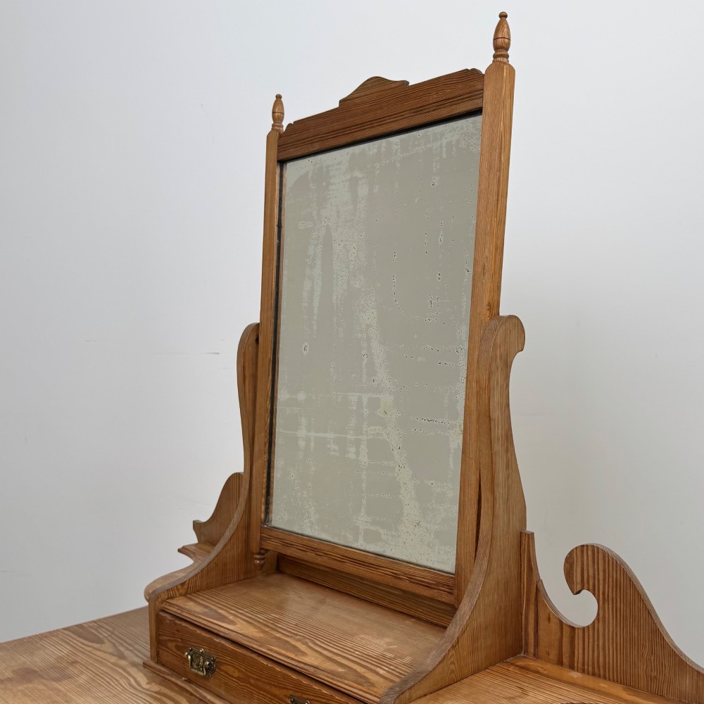 A Victorian pitch pine dressing table featuring a central swivel mirror, side scroll shelves, frieze drawers with brass handles, and turned legs with a low shelf. View XI